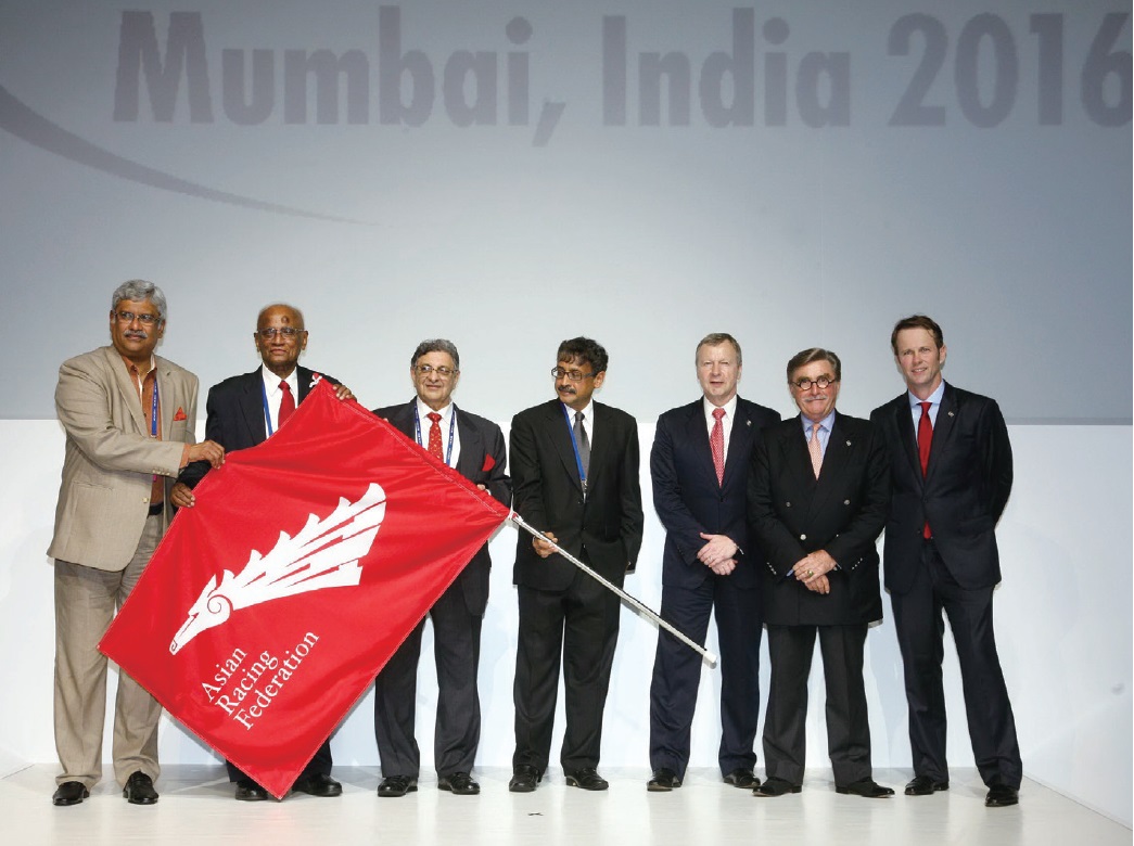The ARF flag is passed from Hong Kong to India, which will become the host country for the 36th Asian Racing Conference. From right: Secretary-General of the ARF Andrew Harding; HKJC Chairman T. Brian Stevenson; New ARF Chairman and HKJC CEO Winfried Engelbrecht-Bresges; and Chairman of the Turf Authority of India Vivek Jain.