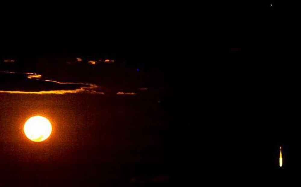 Reader submitted image shows a flaming object falling from the night sky on the right of the picture. Photo: Screenshot