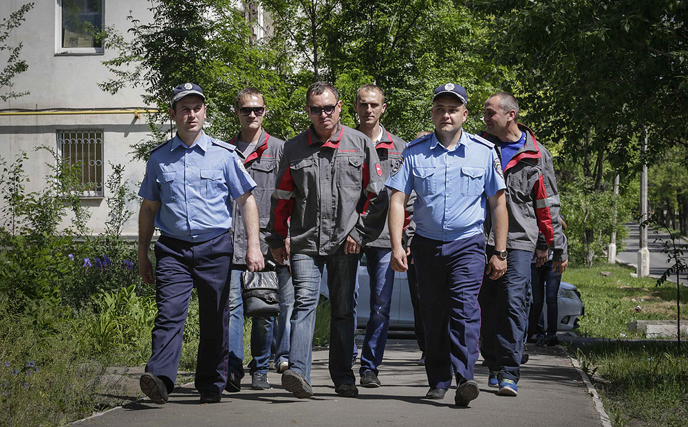 Workers of Metinvest, majority-owned by Rinat Akhmetov's System Capital Management, and police officers conduct a joint patrol in Mariupol on Friday. Photo: Reuters