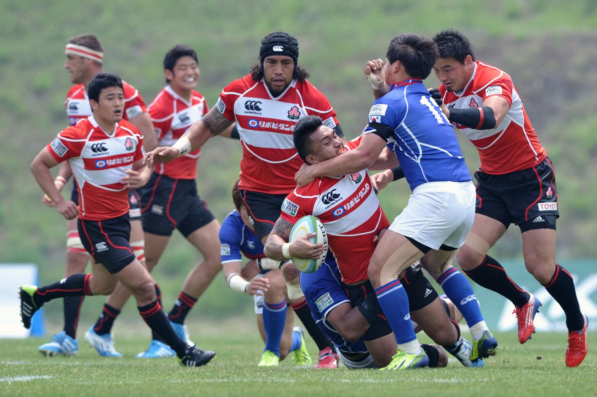 Japan's Male Sau (centre) tries to fend off a Korean tackle during the match in Incheon on Saturday. Photo: AFP