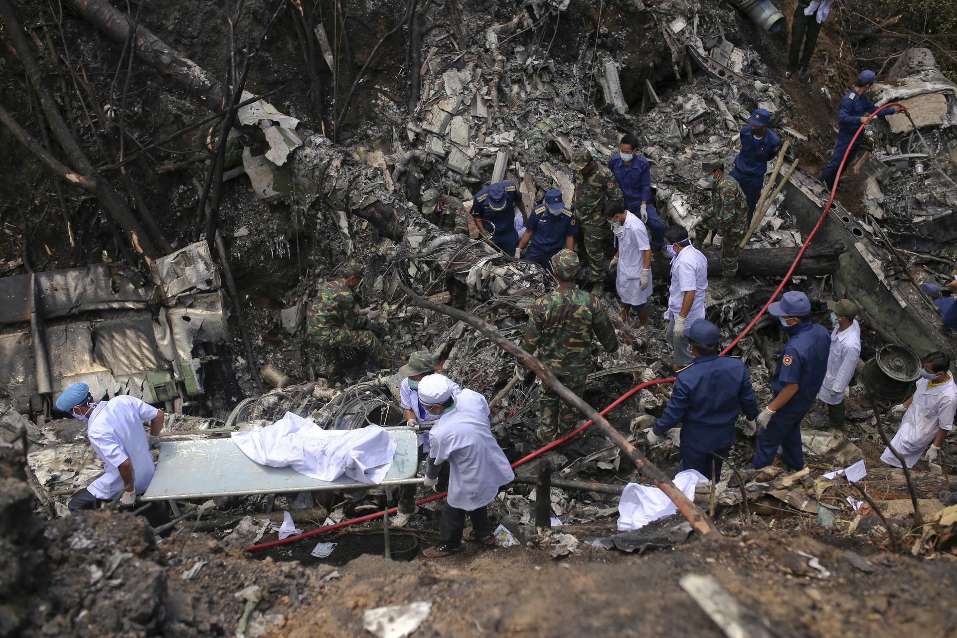 Rescue workers search the site near Nadee village, in Xiangkhouang province, where a Laotian air force plane crashed. Photo: Reuters