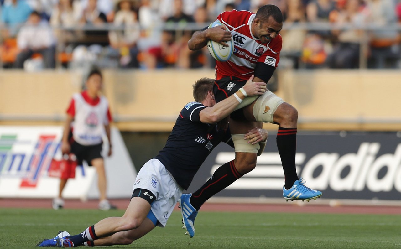 Alex McQueen demonstrates Hong Kong’s strength in defence as he tackles Japan captain Michael Leitch in Tokyo, but it was their lack of possession that proved too costly for the visitors. Photo: Reuters