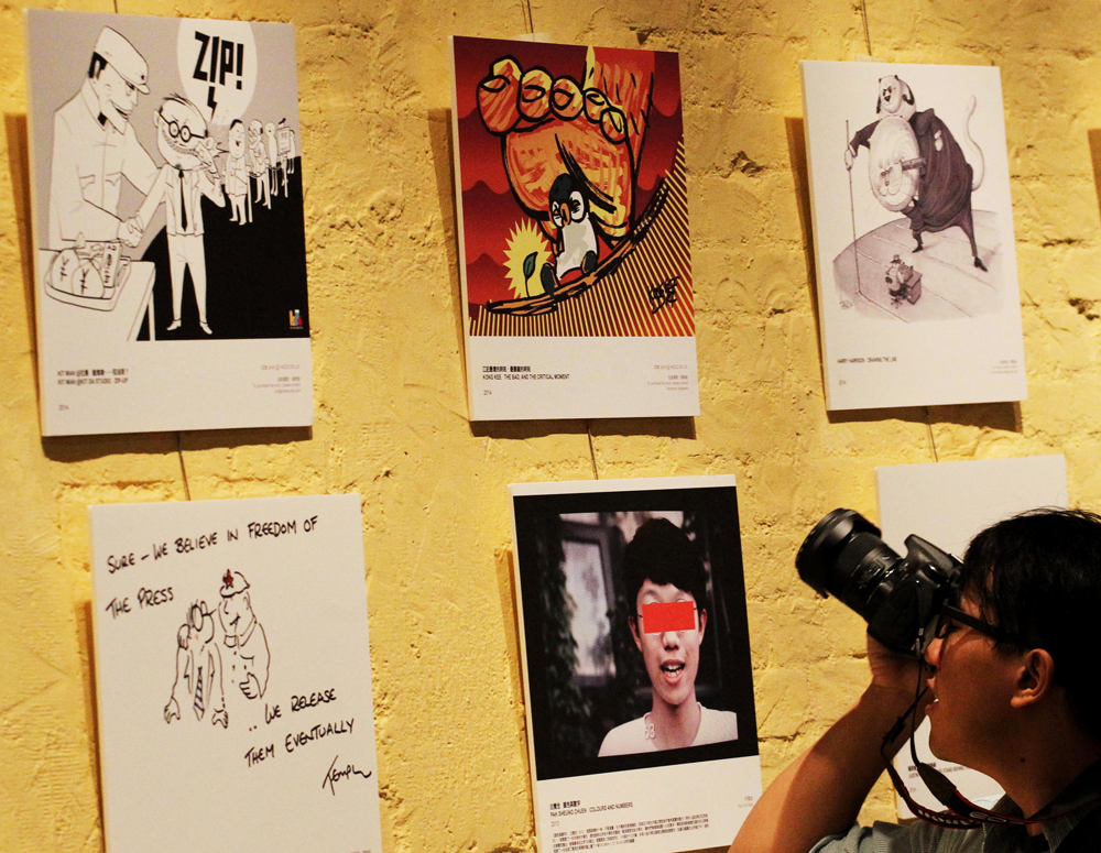 A visitor takes a snap of works by local artists at the Foreign Correspondents' Club. Photo: Felix Wong
