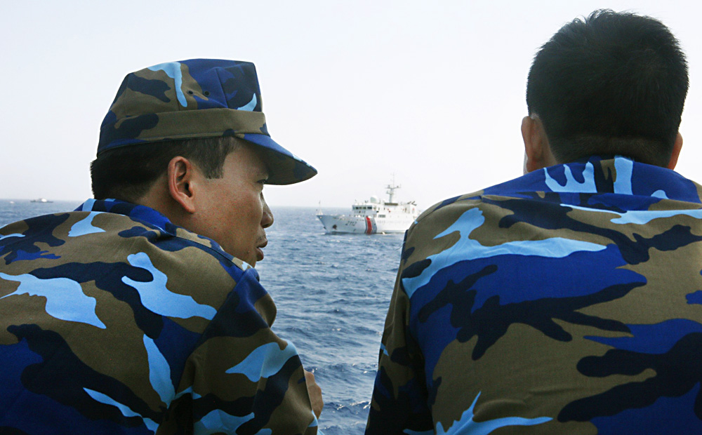 Officers of the Vietnamese Marine Guard talk as they monitor a Chinese coastguard vessel in the South China Sea, about 210km off the shore of Vietnam. Photo: Reuters