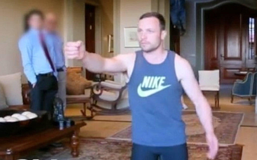 Footage shows Pistorius acting out the night of the killing. He holds his hand in front of him like a gun. Photo: SCMP Pictures