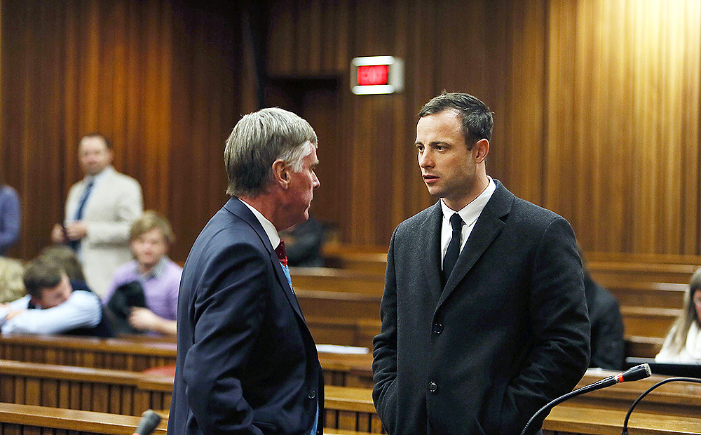 Oscar Pistorius speaks to Brian Webber from his defence team at a court in Pretoria. Photo: AFP