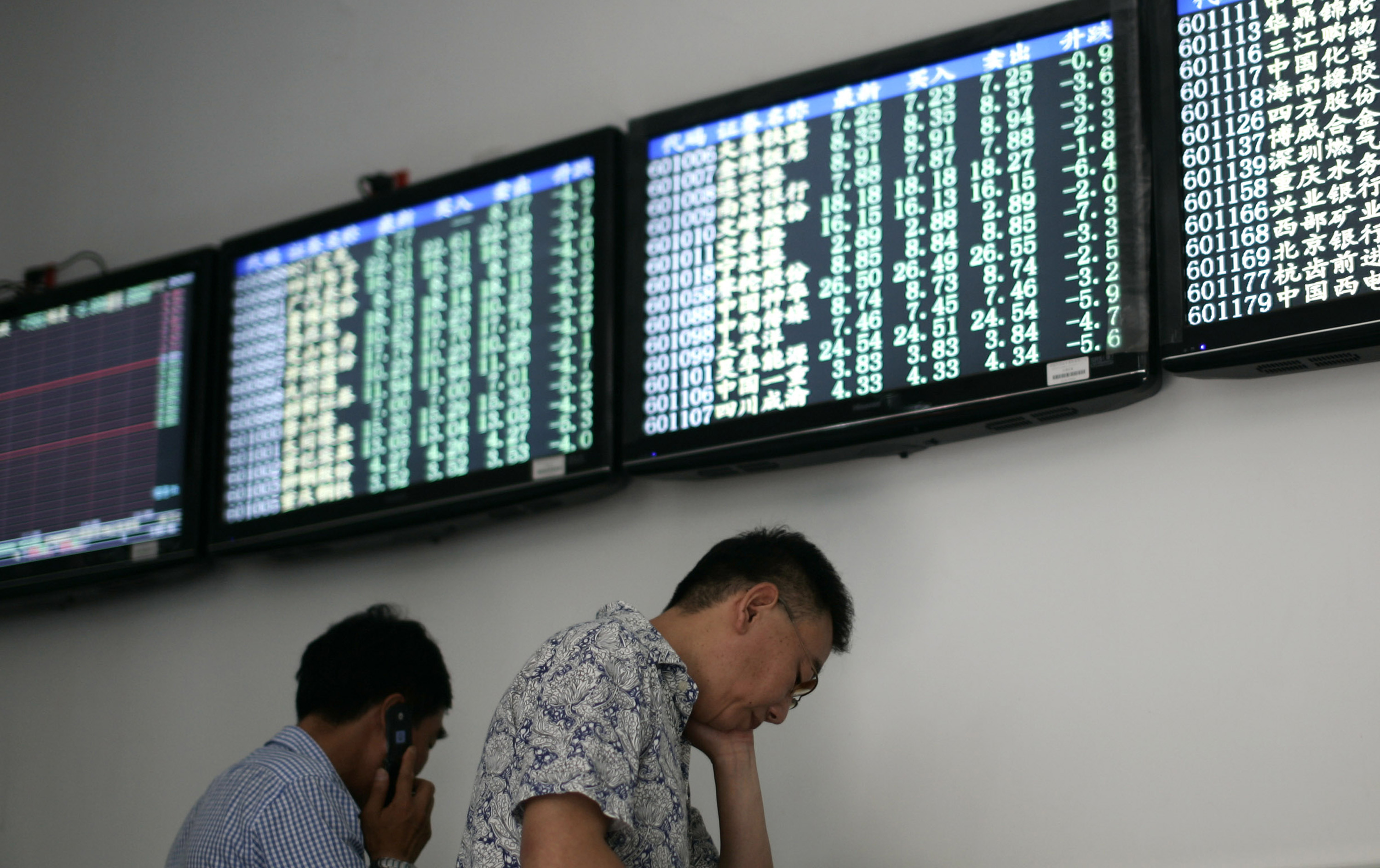 Investors trade under the stock price monitors at a private securities company in Shanghai. Photo: AP