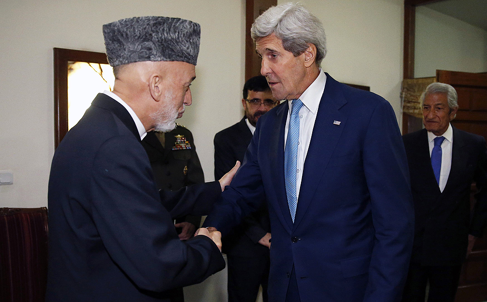 US Secretary of State John Kerry is greeted by Afghanistan's President Hamid Karzai as he arrives for a dinner at the presidential palace in Kabul on Friday. Photo: Reuters