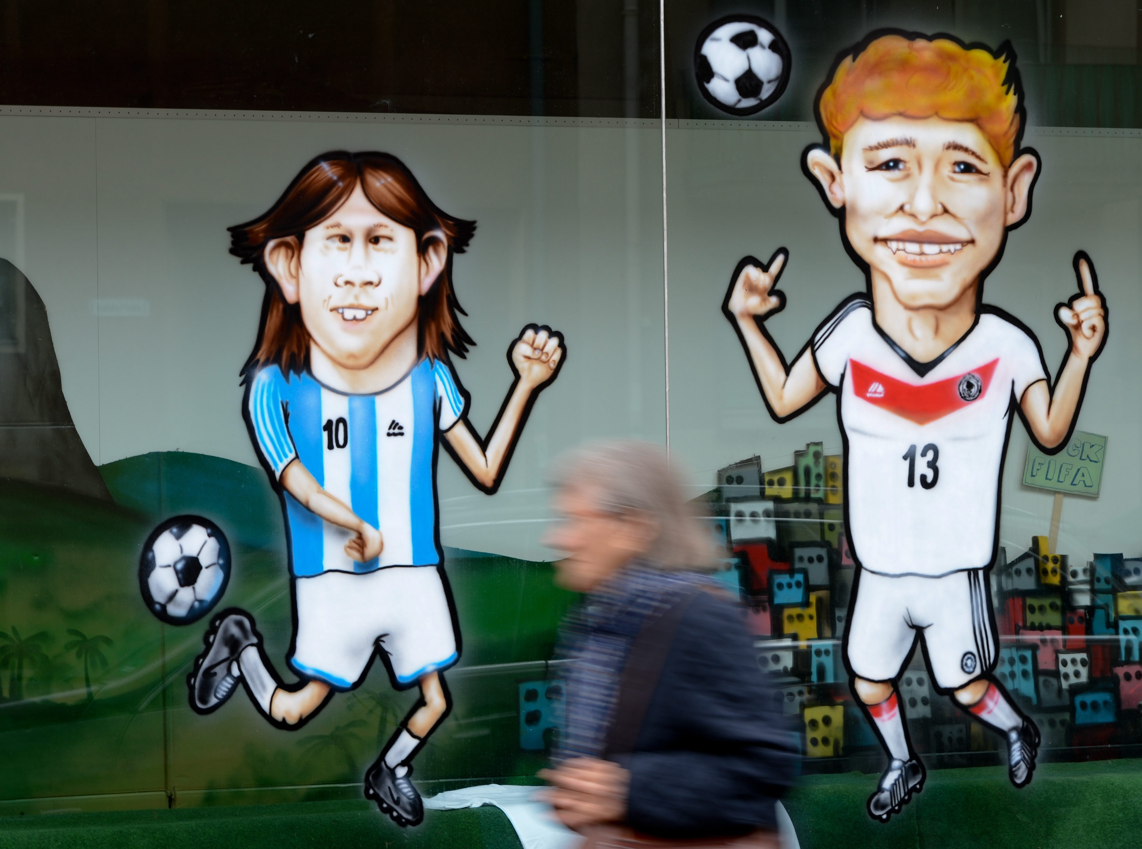 Caricatures of Argentina's Lionel Messi (left) and Germany's Thomas Mueller adorn the windows of a textile printing store in Frankfurt, Germany. Photo: EPA