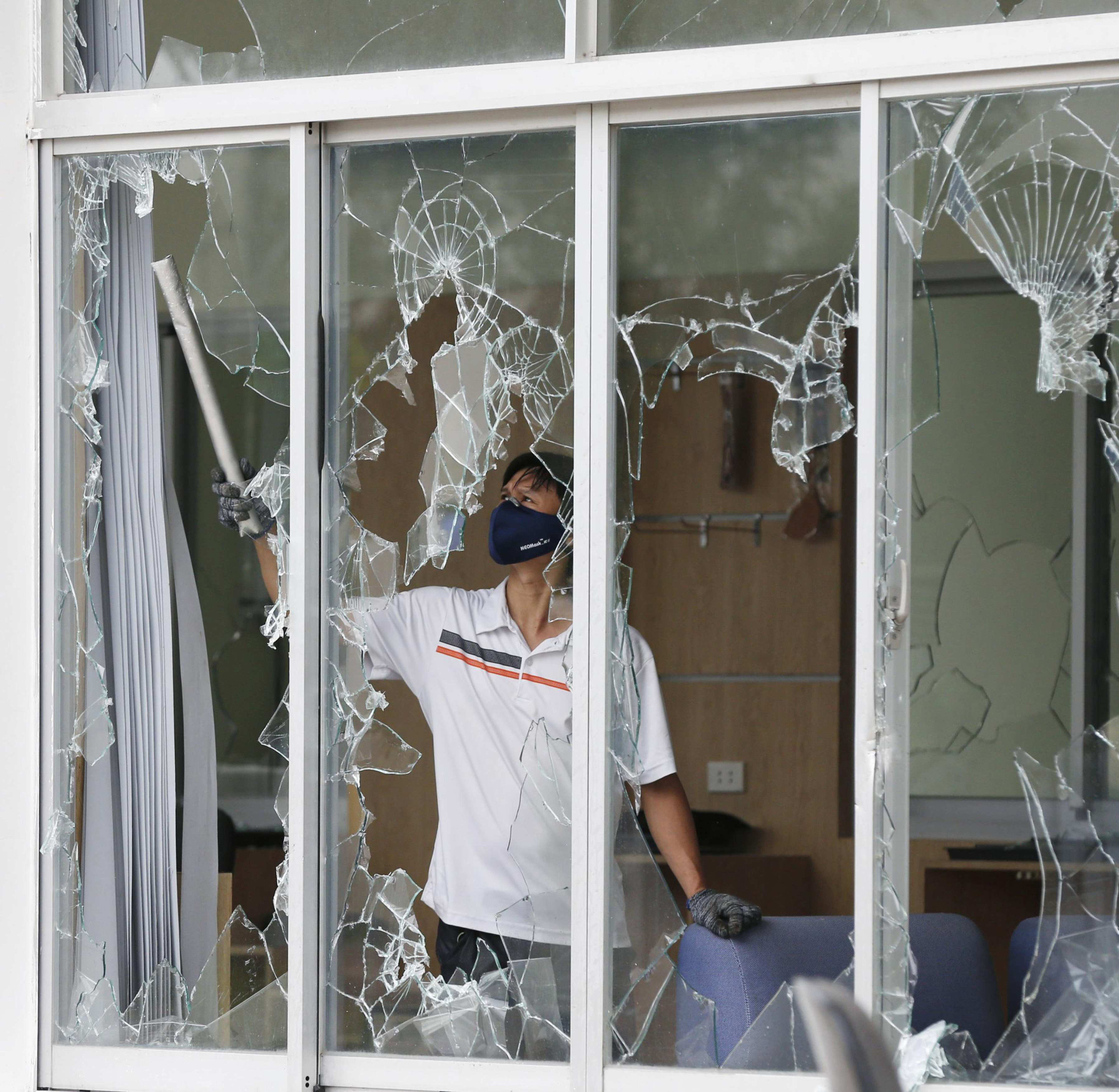A man clears broken windows at the office of a Taiwanese company attacked in anti-China protests in Vietnam. Photo: Reuters