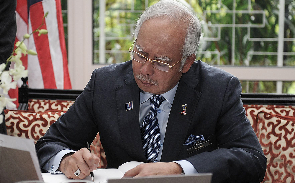 Malaysia's Prime Minister Najib Razak signs a condolence book for the victims of flight MH17 at the residence of the Netherlands' ambassador in Kuala Lumpur on Thursday. Photo: AFP