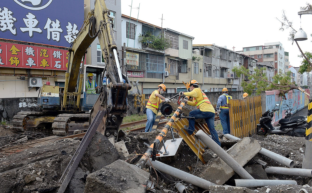 Workers clear debris from an intersection in Kaohsiung. Two firefighters are still missing from the explosions that killed at least 28 people.  Photo: XInhua
