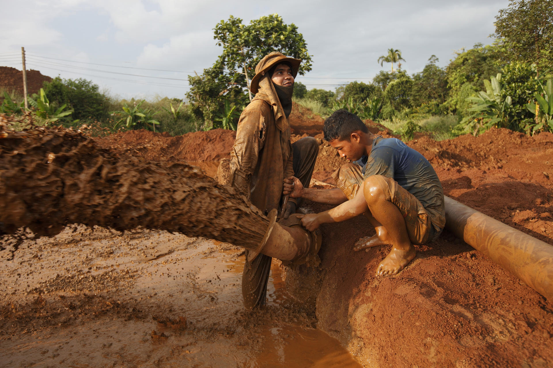 Workers repair a water pipe near a gem mine just outside Chanthaburi, Thailand. 
