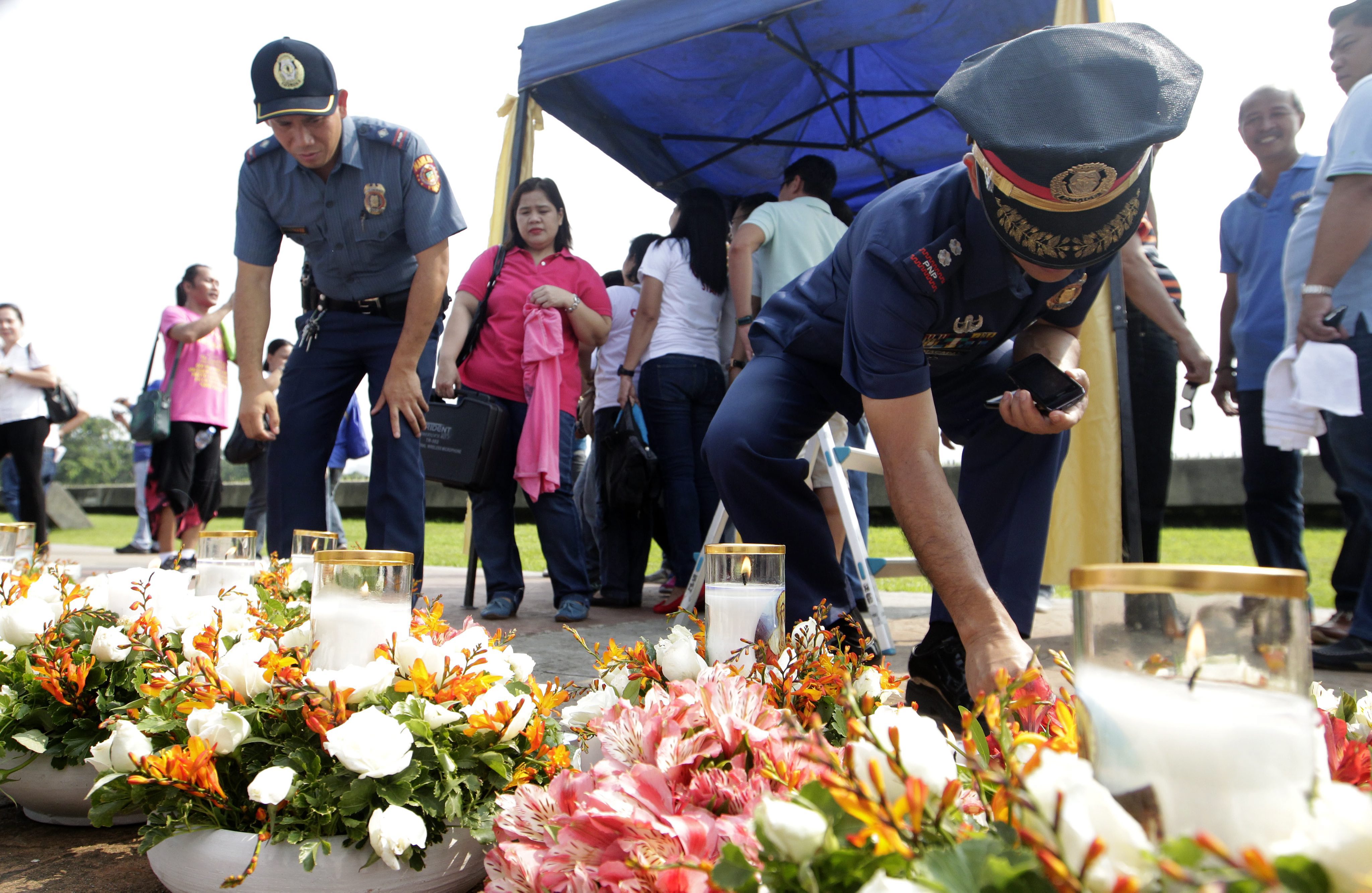 Filipino police officers light candles during the commemoration ceremony in Quirino grandstand, Manila. A disgruntled former cop had hijacked a bus full of Hong Kong tourists in 2010.  Photo: EPA