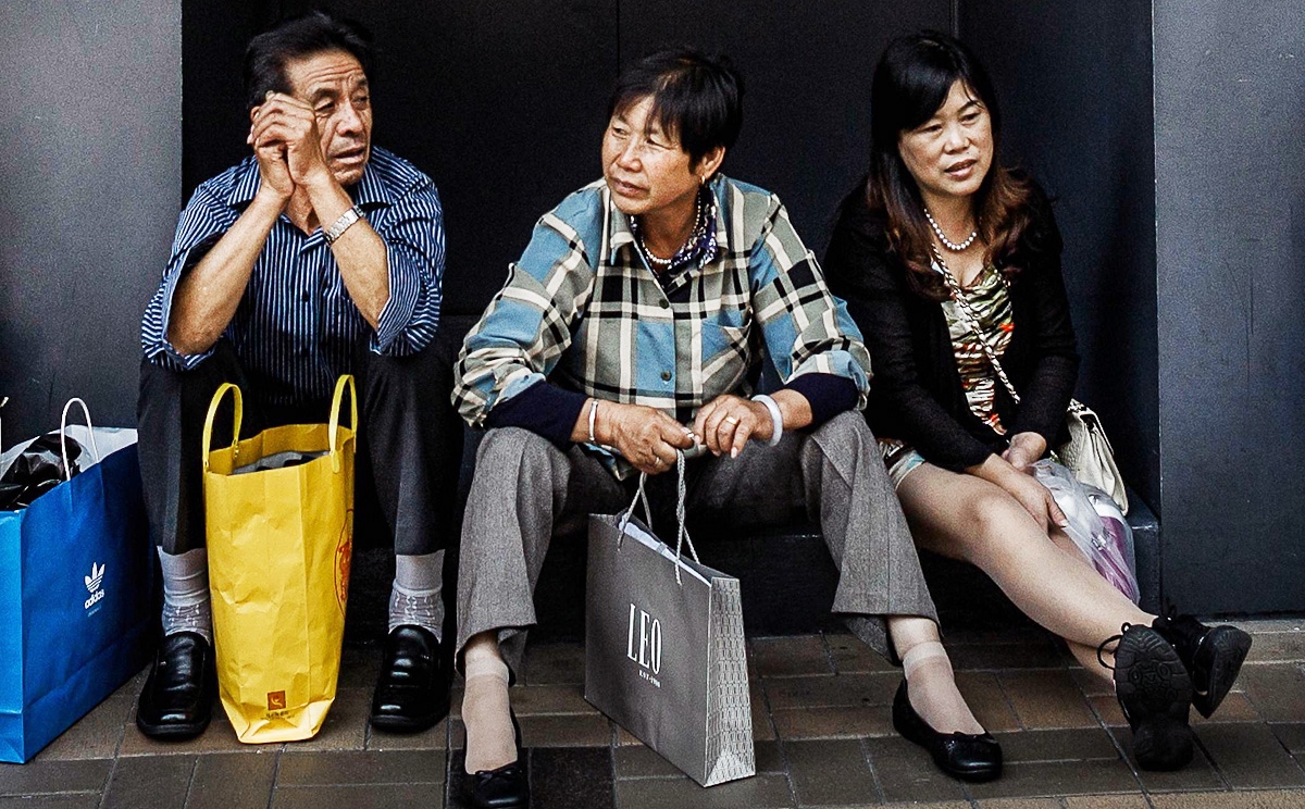 Mainland shoppers sit in front of a shop selling luxury goods in Hong Kong. Photo: AFP