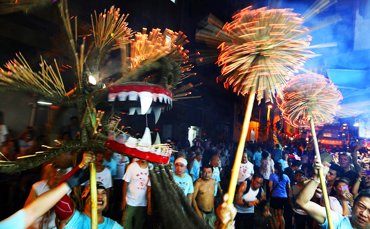 Fire dragon dancers celebrate the Mid-Autumn Festival with a performance in Tai Hang last night, following in a tradition that stretches back more than 130 years and was originally enacted by villagers to ward off plague. In 2011 the dance was included on a national list of intangible cultural heritage. Photo: Felix Wong