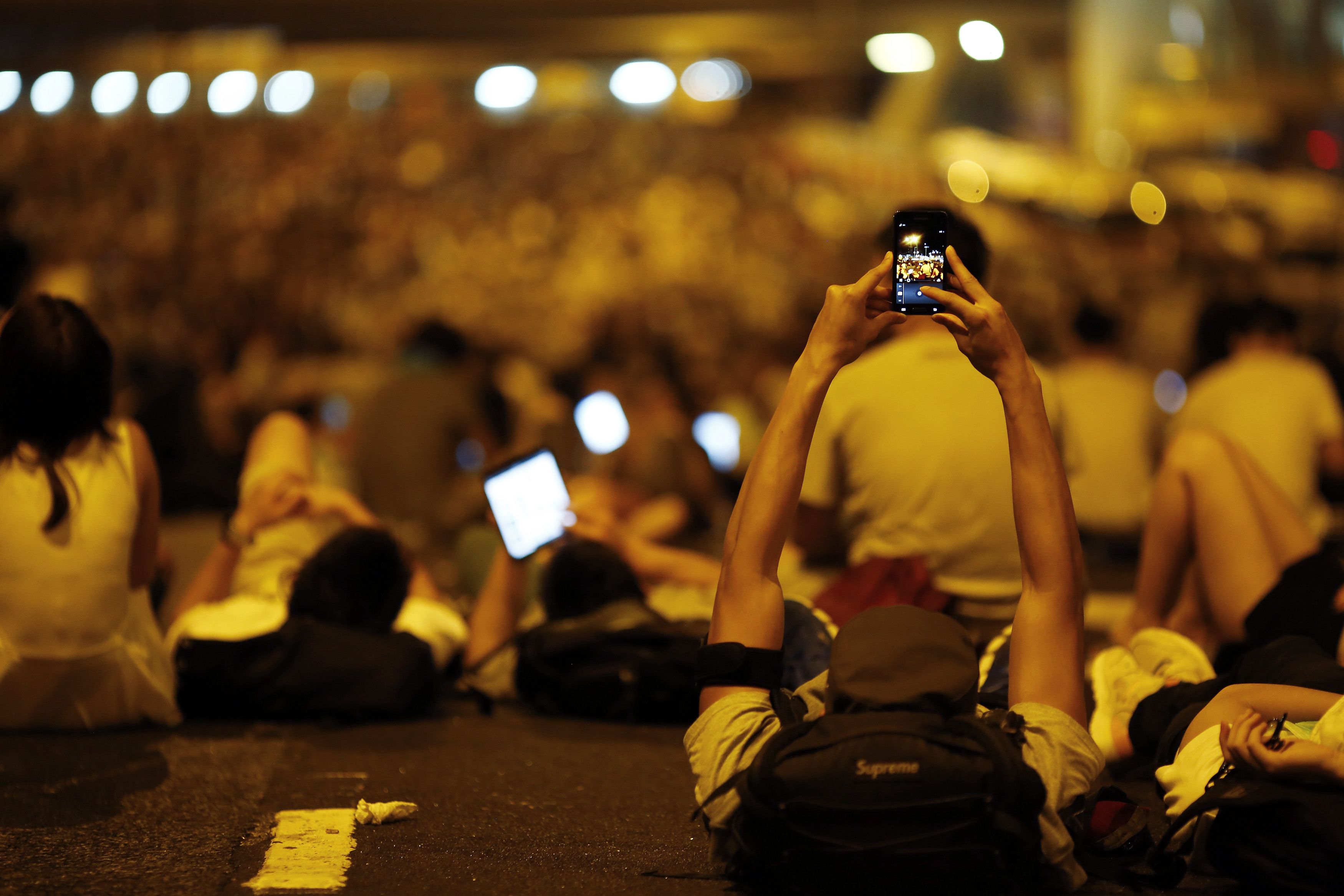 A protester takes pictures of fellow demonstrators with his mobile phone. Photo: Reuters
