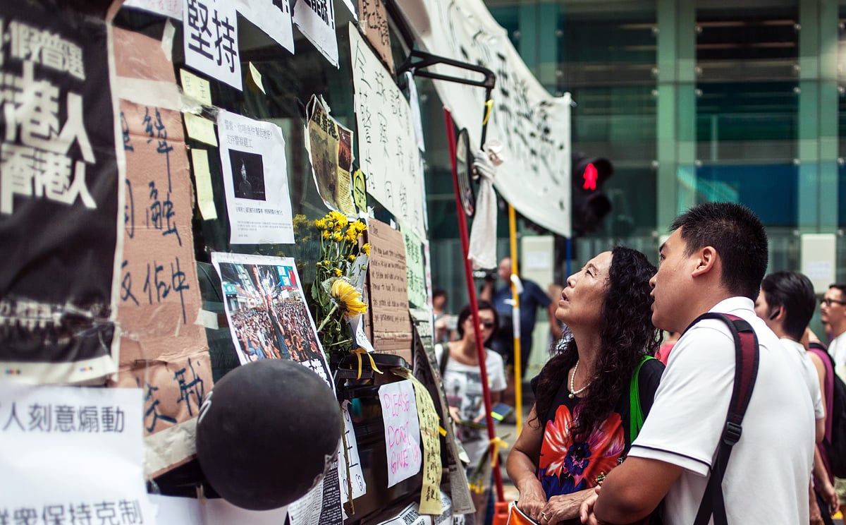 Pedestrians look at notes posted by pro-democracy activists onto a passenger bus that was abandoned due to protests in Kowloon on Tuesday. Photo: AFP