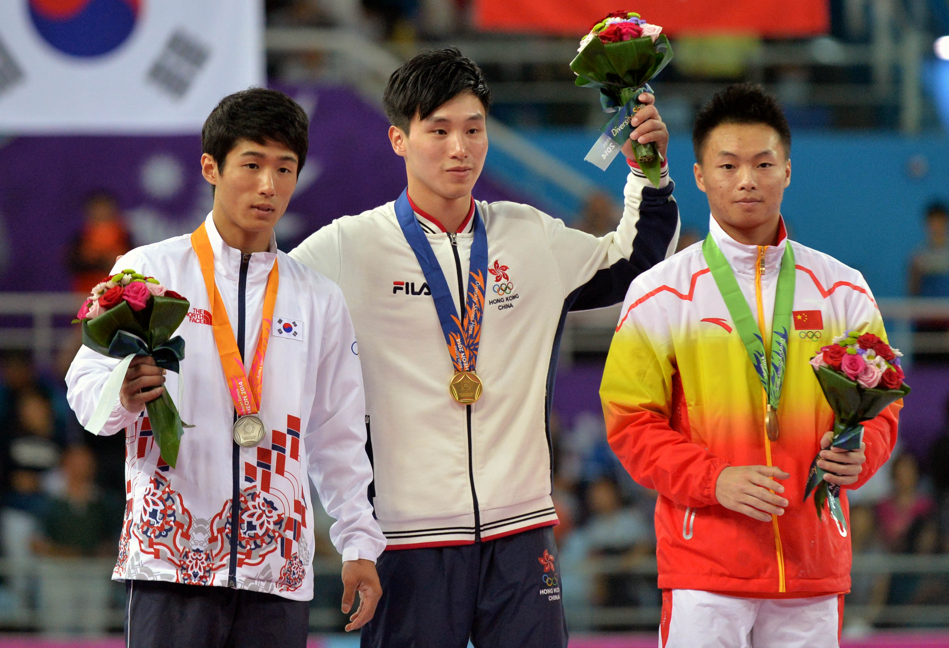 Hong Kong's Shek Wai-hung celebrates an unlikely gold in the men's fault ahead of South Korea's Yang Hakseon bronze medalist Huang Xi of China. Photo: Xinhua