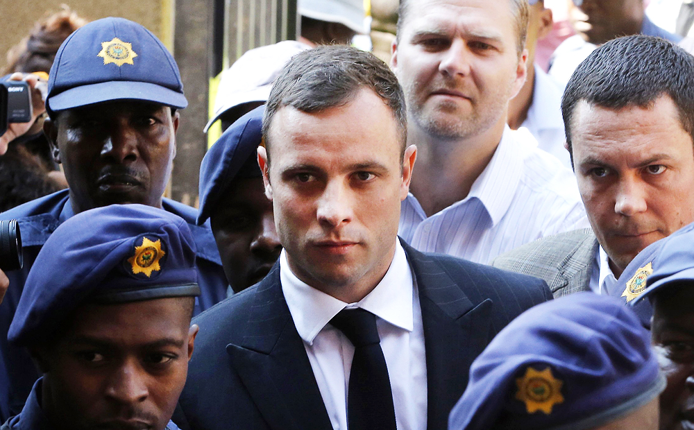 Oscar Pistorius is escorted by police as he arrives at Pretoria High Court on Monday. Photo: AP