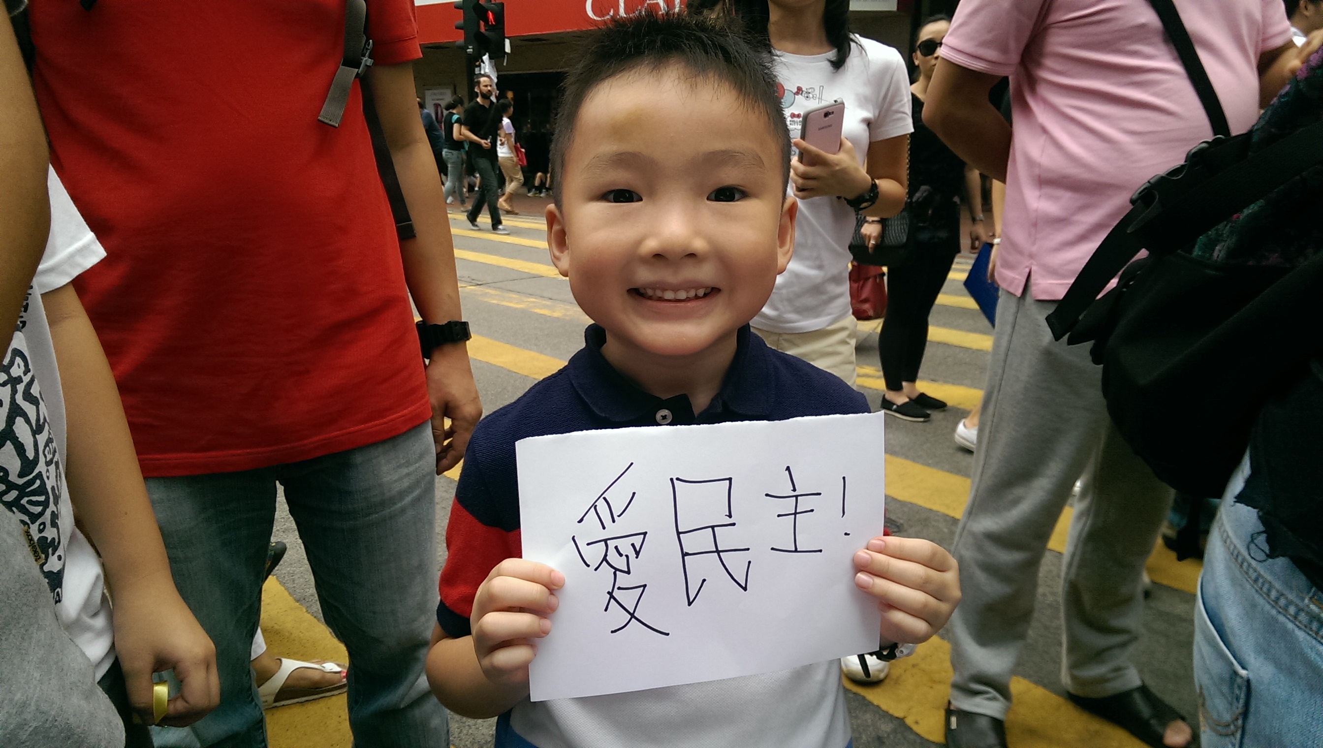 A little boy in the midst of Occupy Central holds up a sign saying "love democracy" in Chinese. Photo: SCMP Pictures