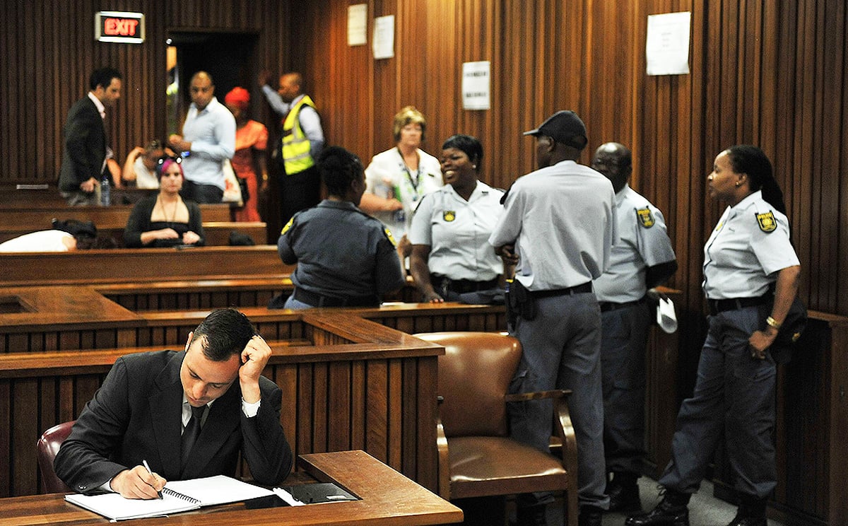 Oscar Pistorius takes notes on the third day of his sentencing during his ongoing murder trial in Pretoria. Photo: AFP