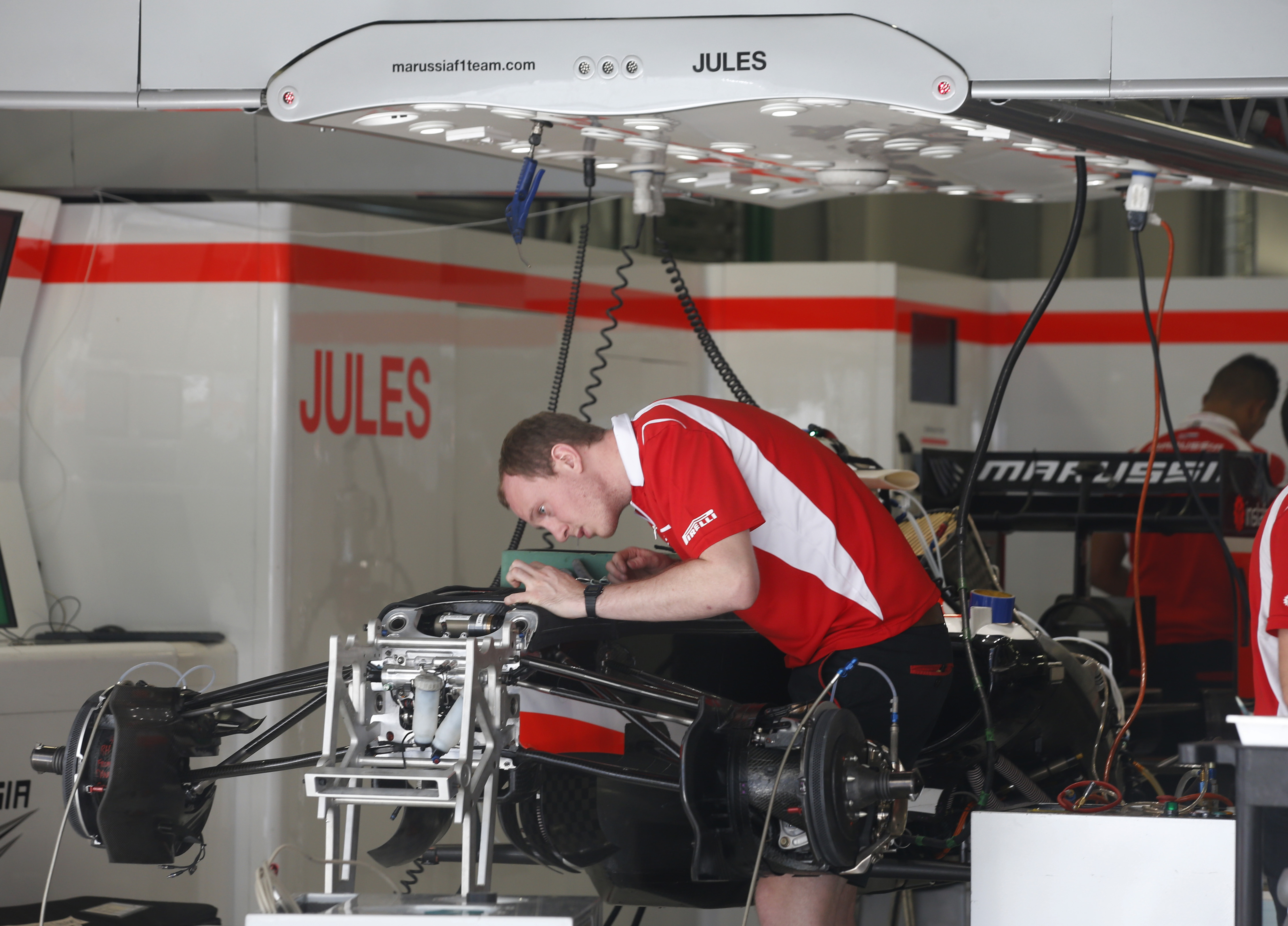 A Marussia mechanic works on a car in the Jules Bianchi garage at the Sochi Autodrom Formula One circuit. Photo: AP