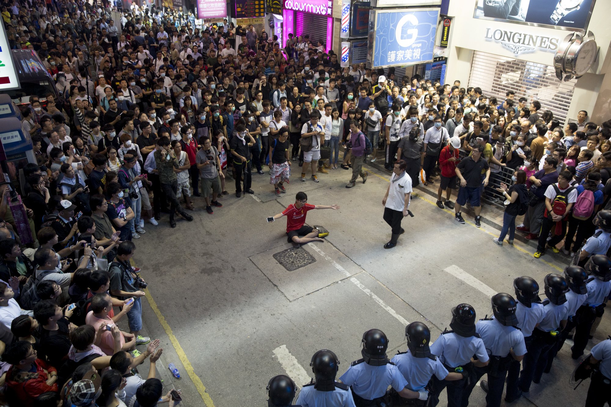 A protester sits facing police in riot gear in Mong Kok. The people of Hong Kong and the government ultimately want the same thing - a better future for Hong Kong. Photo: Bloomberg