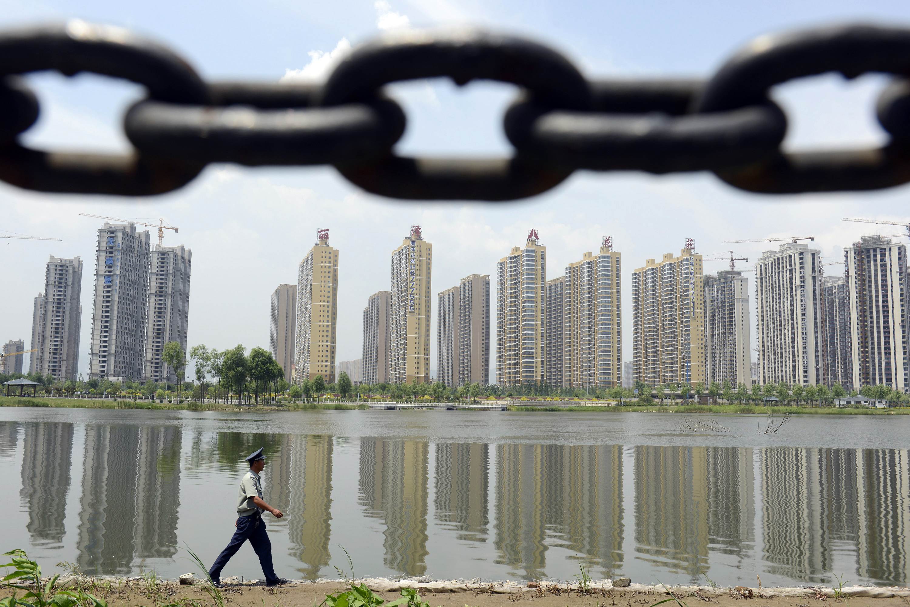 A security guard patrolling along a river bank near a new residential compound in Taiyuan. Photo: Reuters