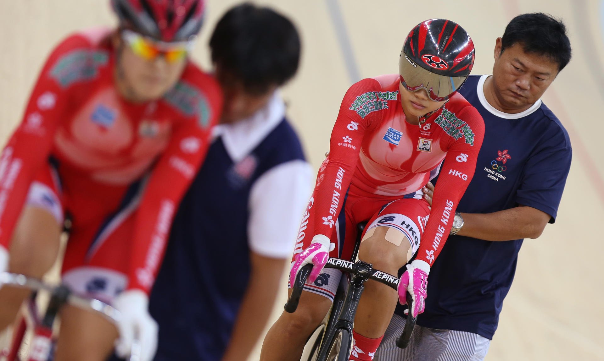 Assistant coach Pu Linjun keeps Sarah Lee steady before the start of the women's sprint against Meng Zhaojuan (front). Photo: Nora Tam