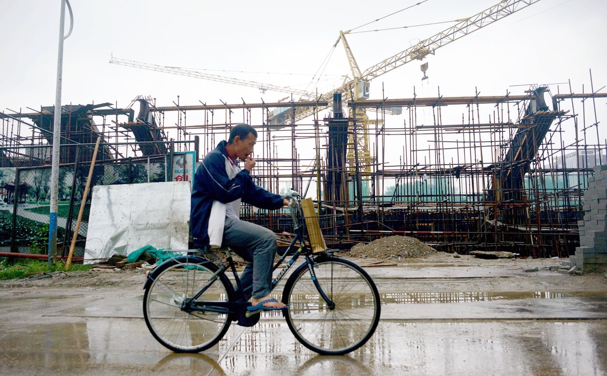 A man rides a bicycle past a construction site in Beijing. An effort is under way to tie the capital, Tianjin and Hebei more closely together economically. Photo: AFP
