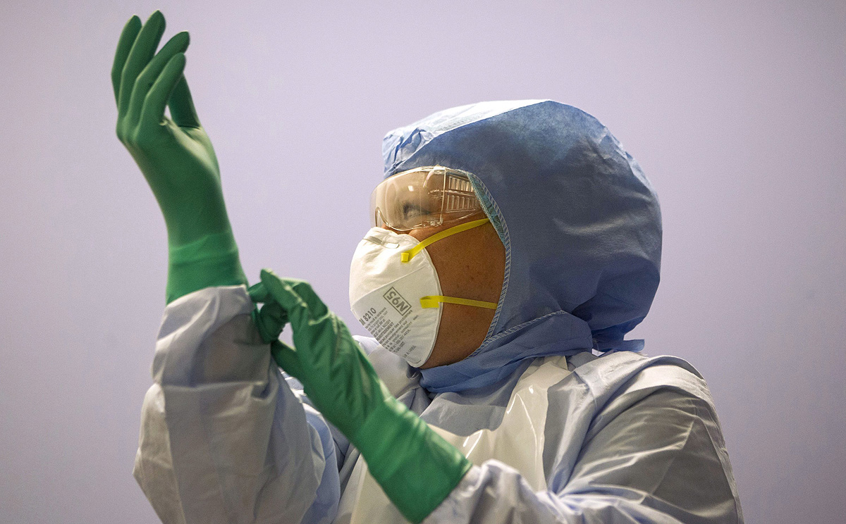 A Canadian healthcare worker pulls on a third pair of gloves during a Personal Protective Equipment procedures demonstration at Toronto Western Hospital. Photo: AP