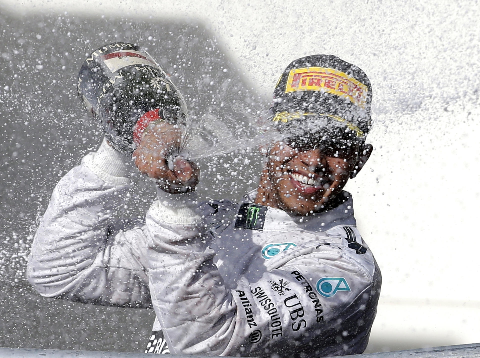 Mercedes driver Lewis Hamilton sprays champagne after winning the Formula One US Grand Prix. Winning races means more money for teams. Photo: AP 
