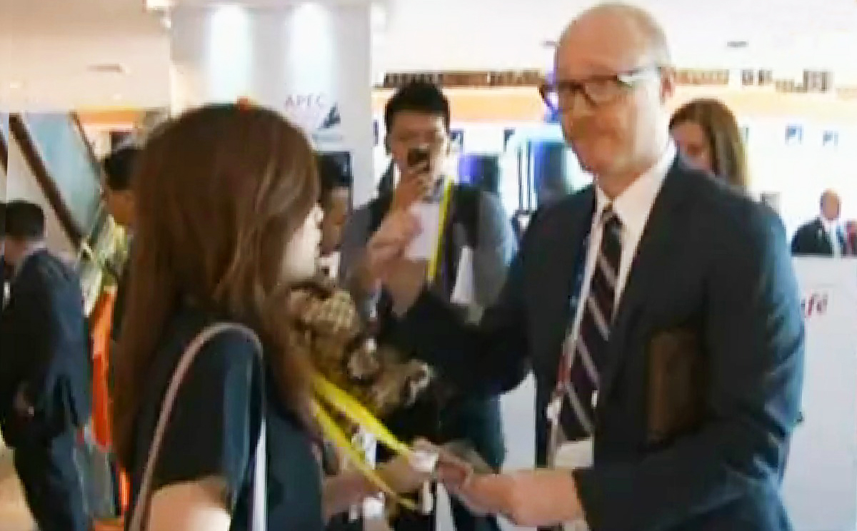 An Apec staff member tries to remove a Now TV reporter's press credentials during last year's Apec summit in Bali. Photo: Now TV