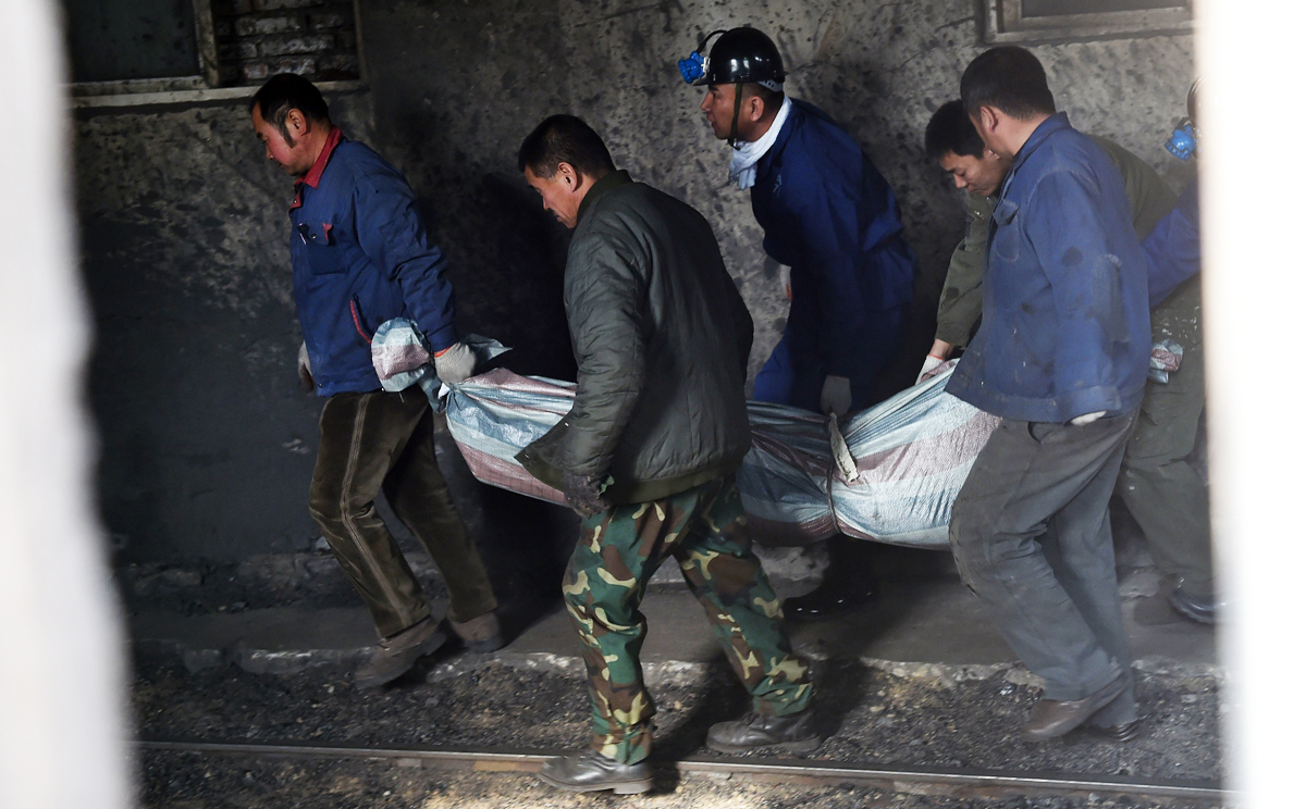 Rescuers carry a body of a victim from Hengda coal mine in Fuxin,  Liaoning. Photo: Xinhua
