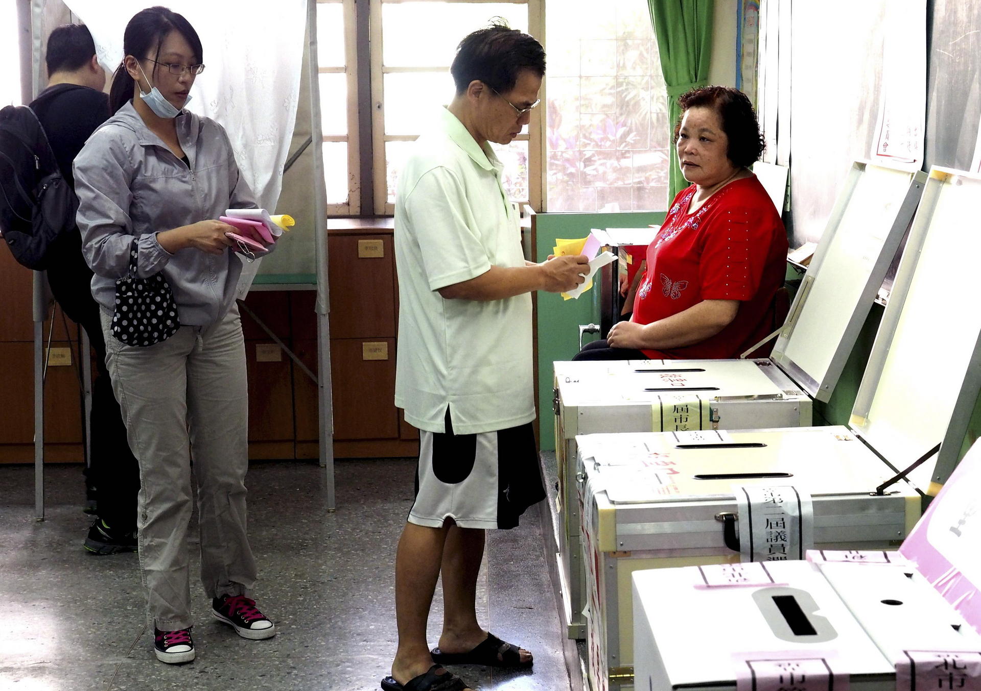 Voters cast their ballots at a polling station in New Taipei City. The KMT held on in the city, a rare highlight for the party. Photo: EPA