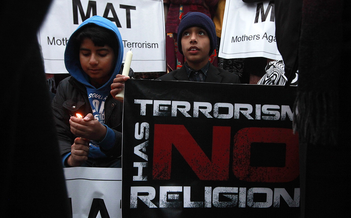 Children hold candles and signs to condemn the Taliban during a rally in Lahore on Friday as Pakistan executed two convicted militants. Photo: Reuters
