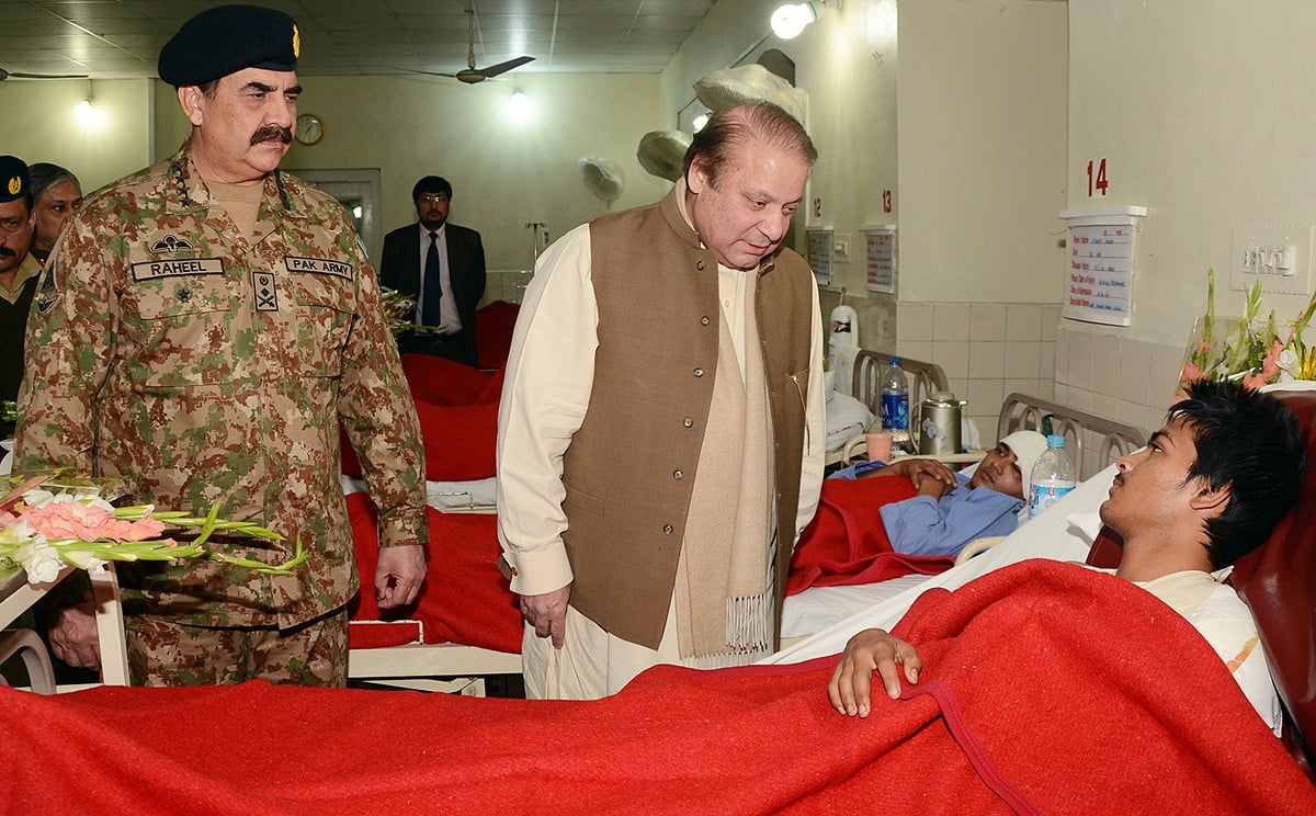 Pakistani Prime Minister Nawaz Sharif (centre) talks to an injured student as army chief General Raheel Sharif stands by. Photo: AFP