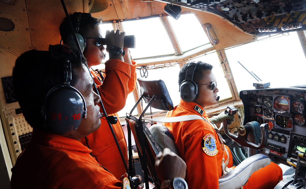 Crew of Indonesian Air Force C-130 airplane of the 31st Air Squadron scan the horizon during a search operation for the missing AirAsia flight 8501 over the waters of Karimata Strait in Indonesia. Photo: AP