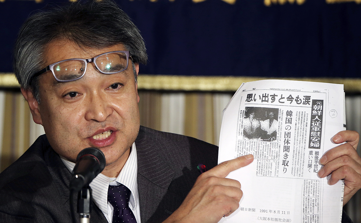 Takashi Uemura, a former journalist with the Asahi newspaper, shows a copy of his story on comfort women during a press conference in Tokyo on Friday. Photo: AP