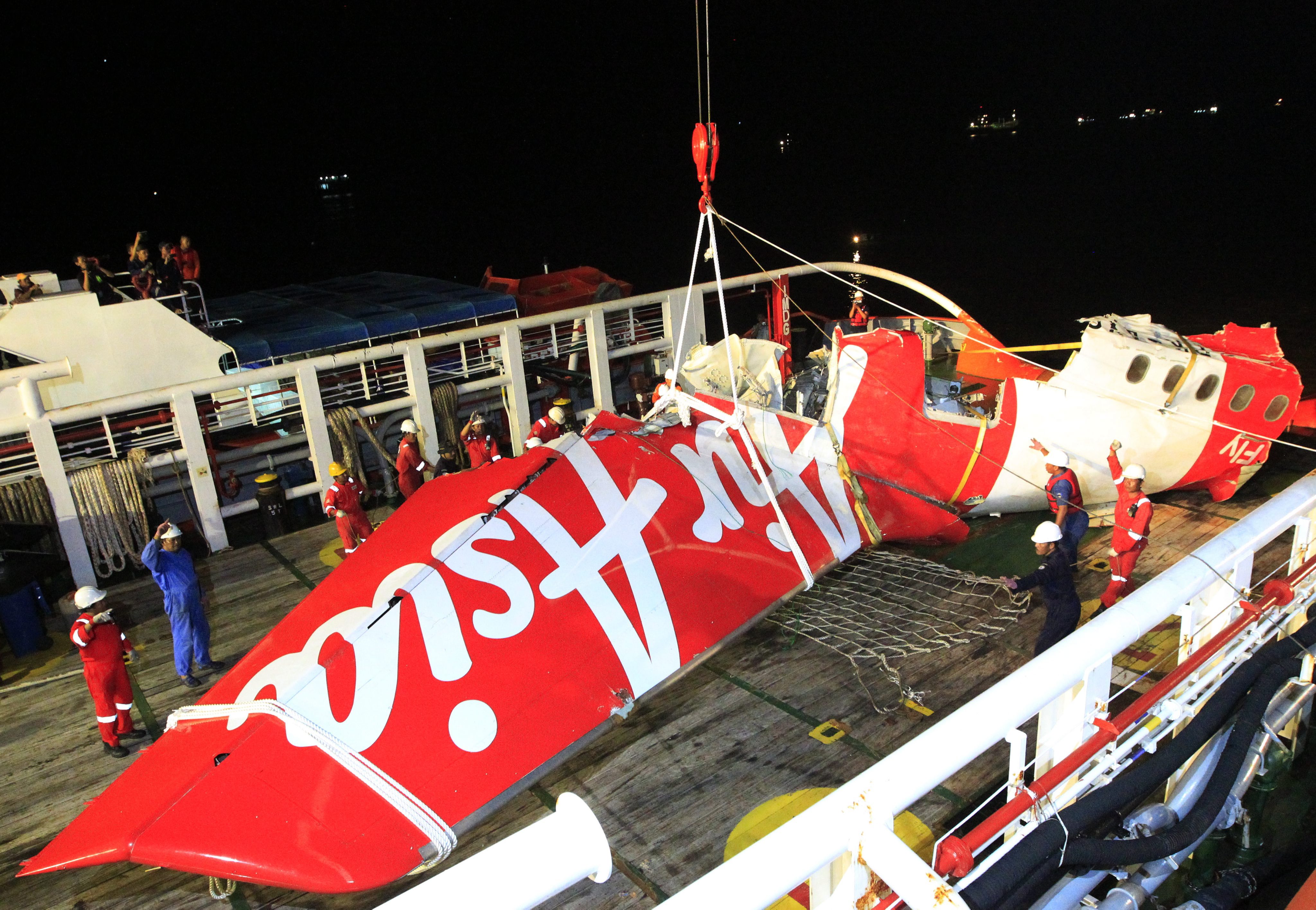Indonesian national search and rescue agency's crew lifts up the wreckage of AirAsia QZ8501 aircraft tail from the Crest Onyx ship. Photo: EPA