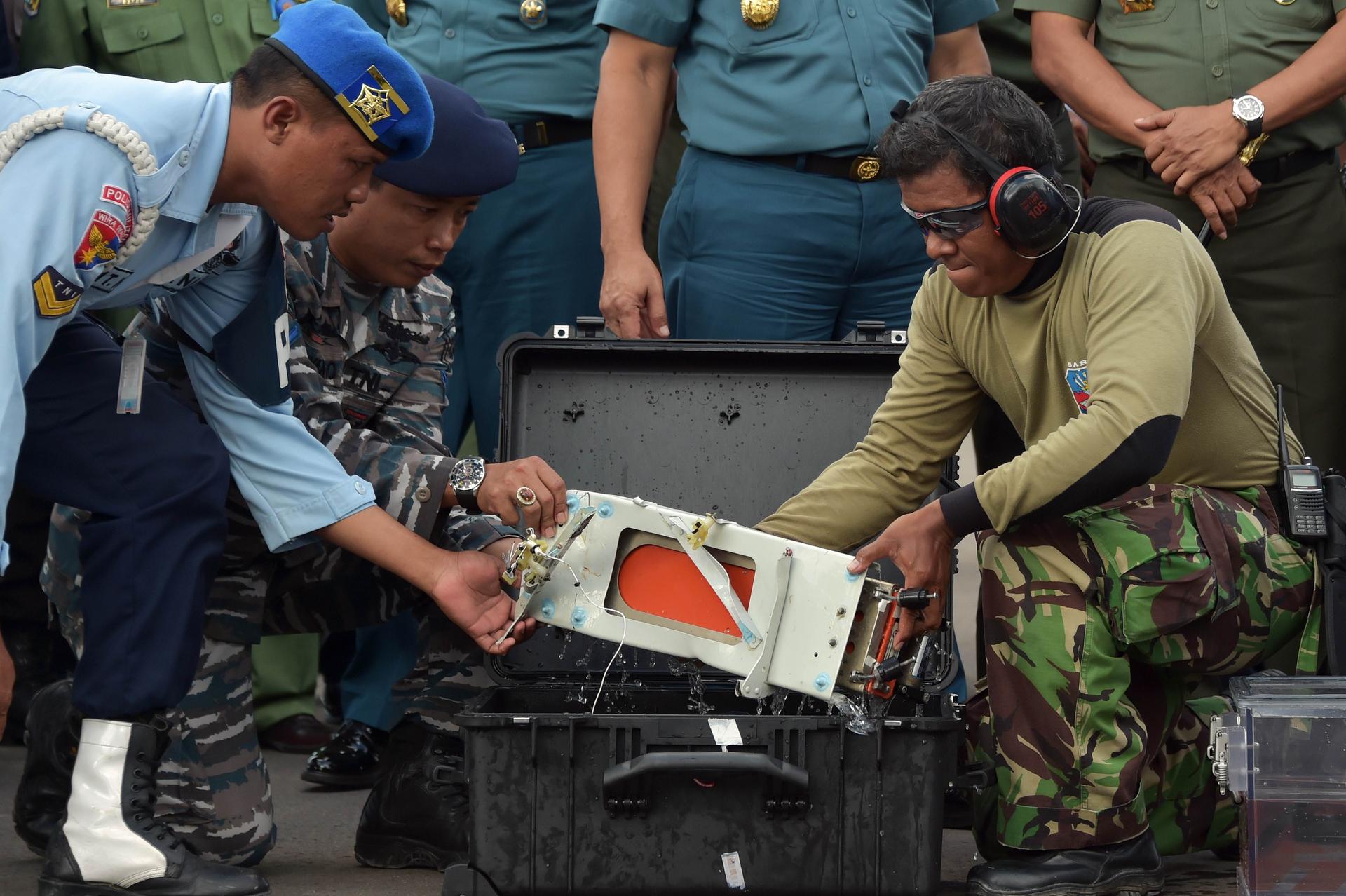 Officers move flight data recorder of the AirAsia plane.Photo: AFP