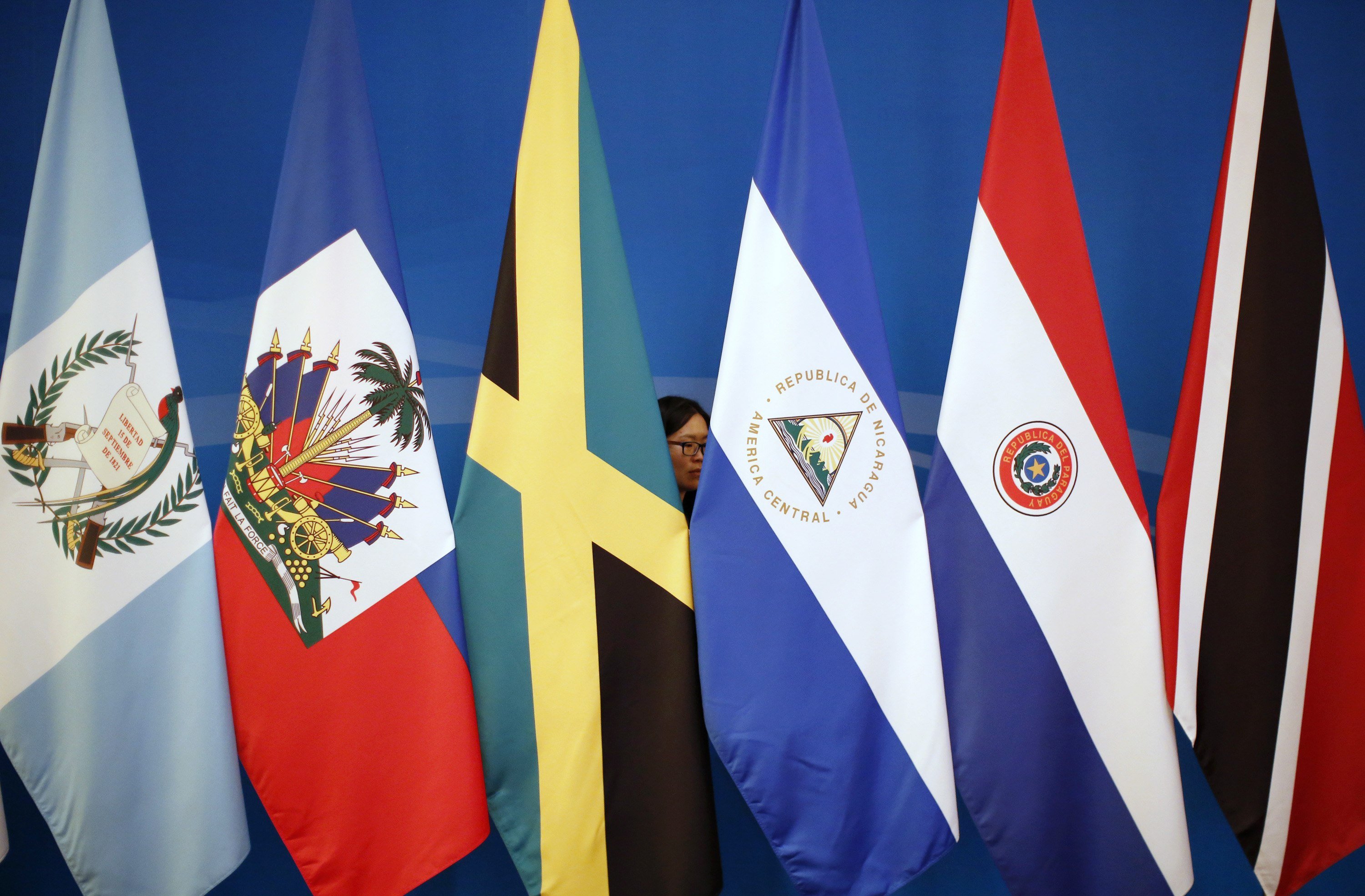 A woman is seen behind the flags of Latin American countries at the two-day forum held in Beijing. Photo: Reuters 