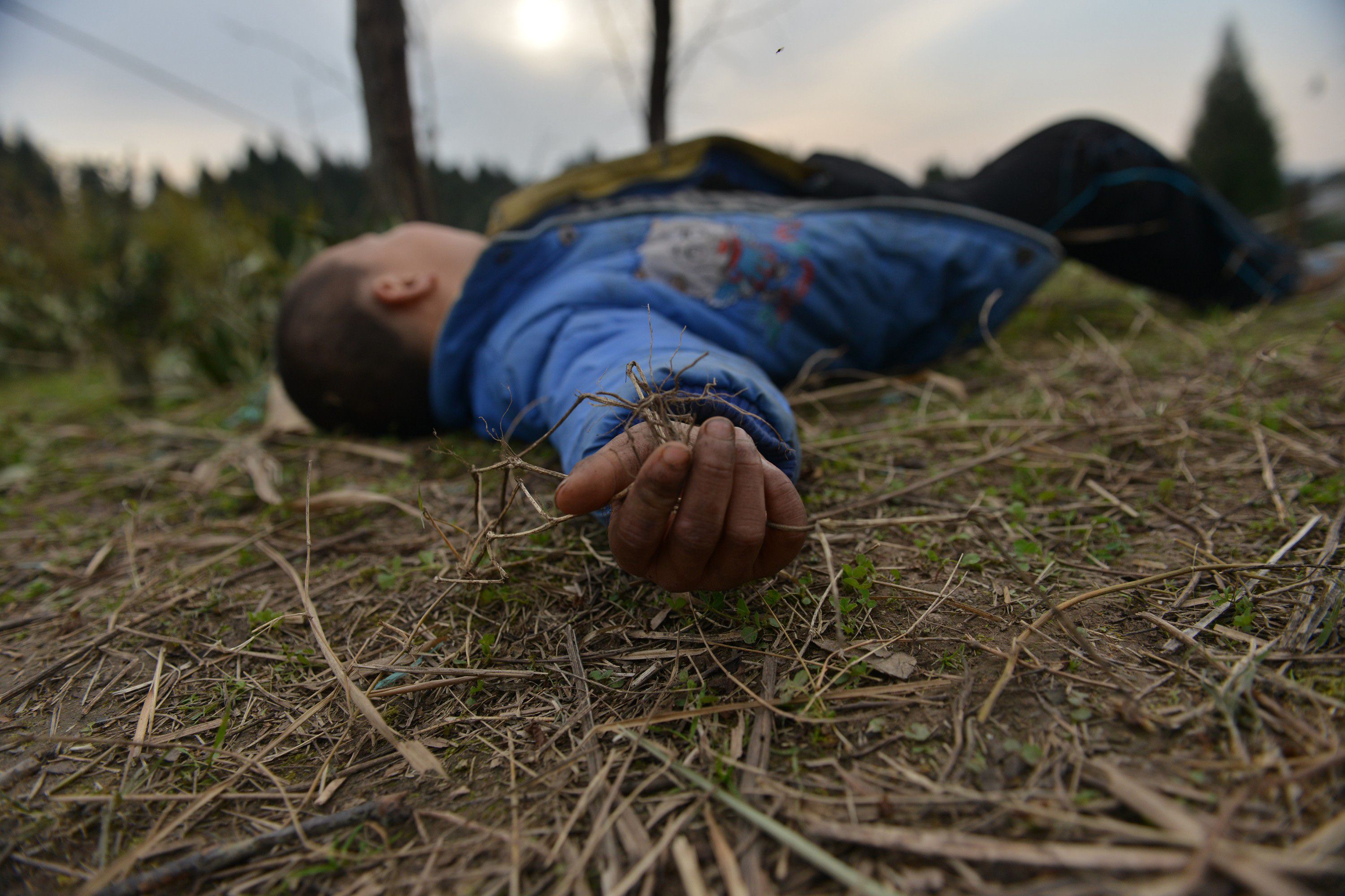 An eight-year-old boy - who suffers from HIV and was given the pseudonym Kunkun by Chinese media - lying on the ground in a village in Xichong county. Photo: AFP