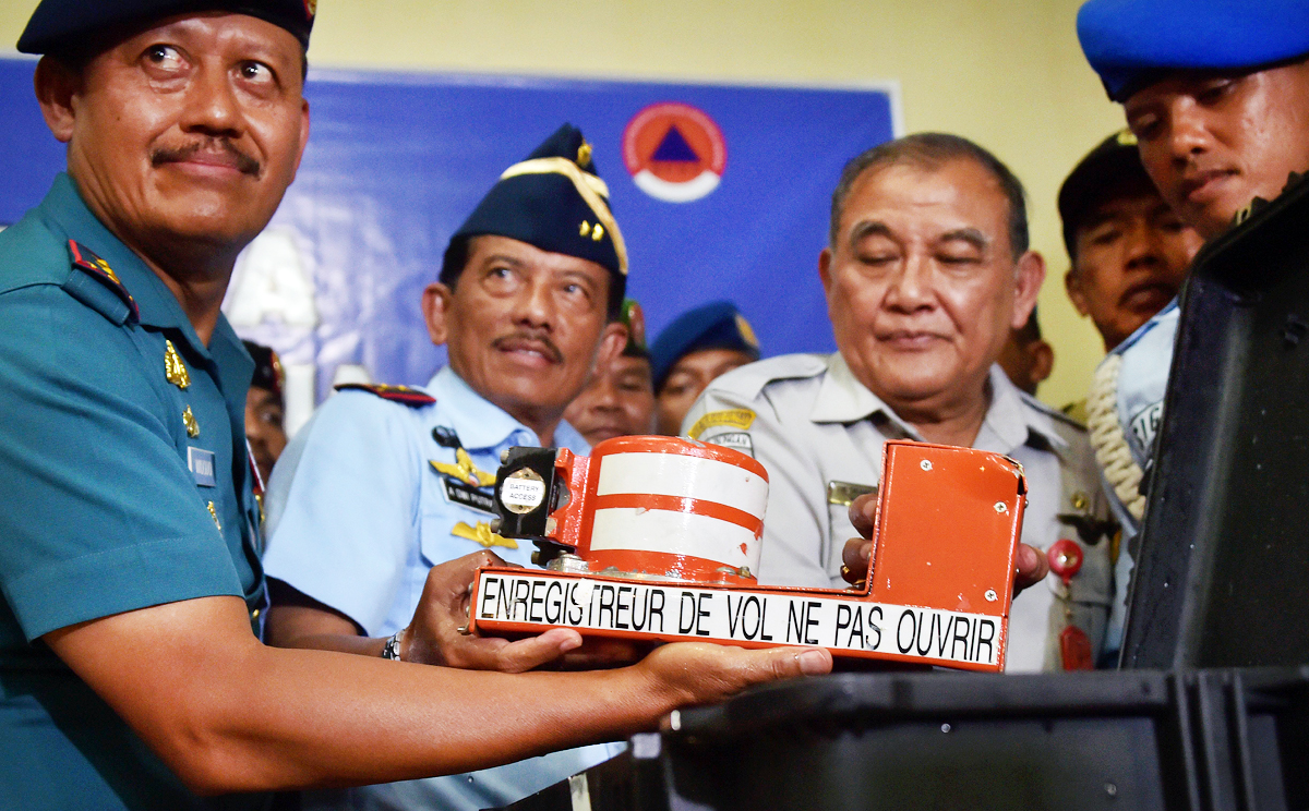 Indonesia's head of the Military Search and Rescue Task Force Widodo (from left), deputy of the Military Search and Rescue Task Force Dwi Kurniadi and Tatang Kurniadi, head of Indonesia's National Transportation Safety committee, hold the cockpit voice recorder from AirAsia flight QZ8501 upon its arrival in Pangkalan Bun. Photo: AFP