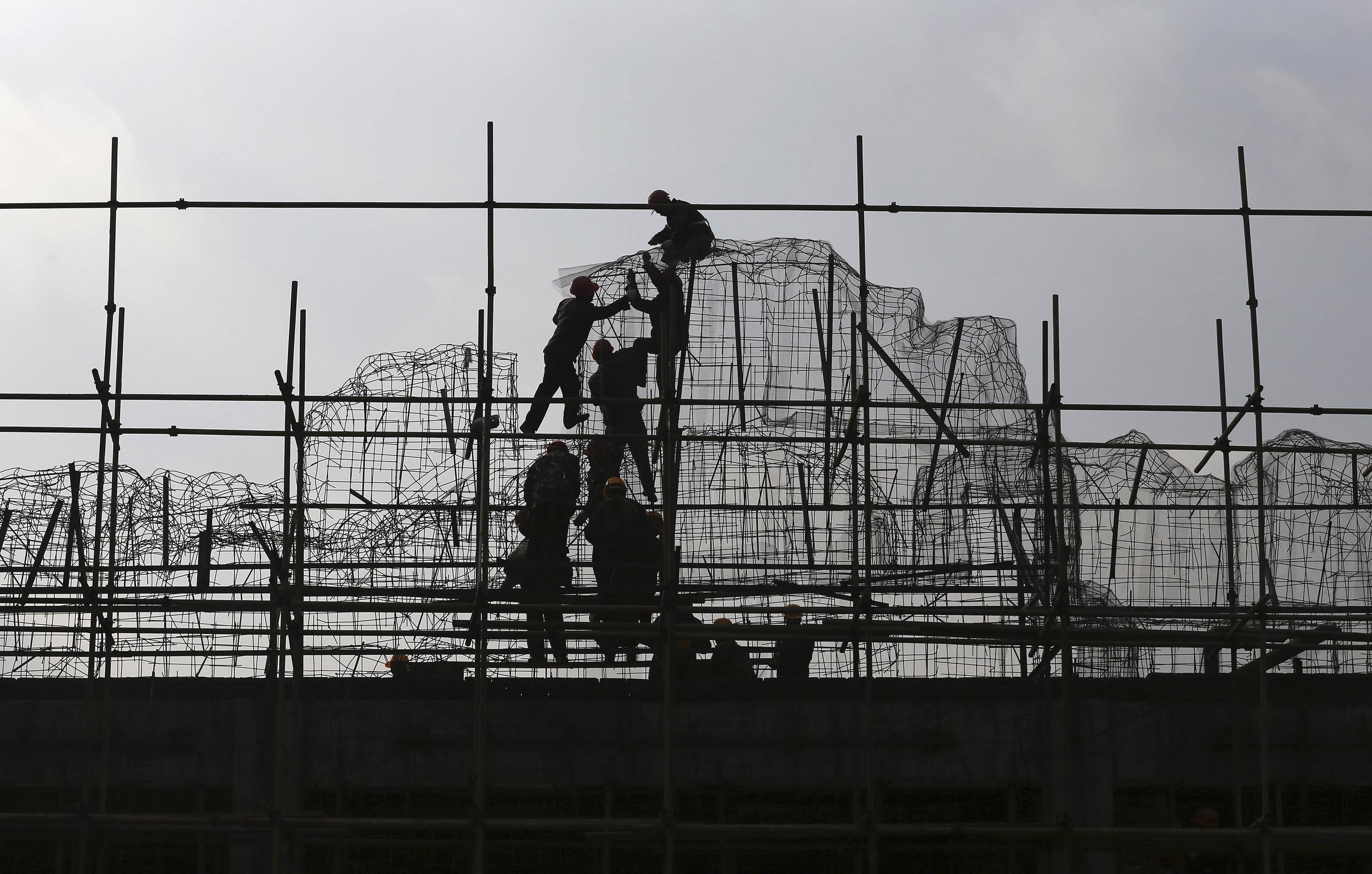Construction workers in Kunming, Yunnan, climb the scaffolding. China's property market is unquestionably cooling down. Photo: Reuters