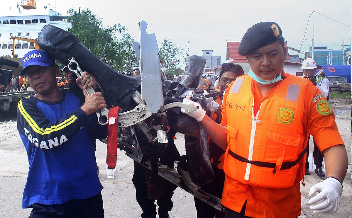 Personnel from Indonesia's national disaster agency carry recovered plane seats from AirAsia flight QZ8501 at the port of Kumai in Central Kalimantan, Borneo. Photo: AFP