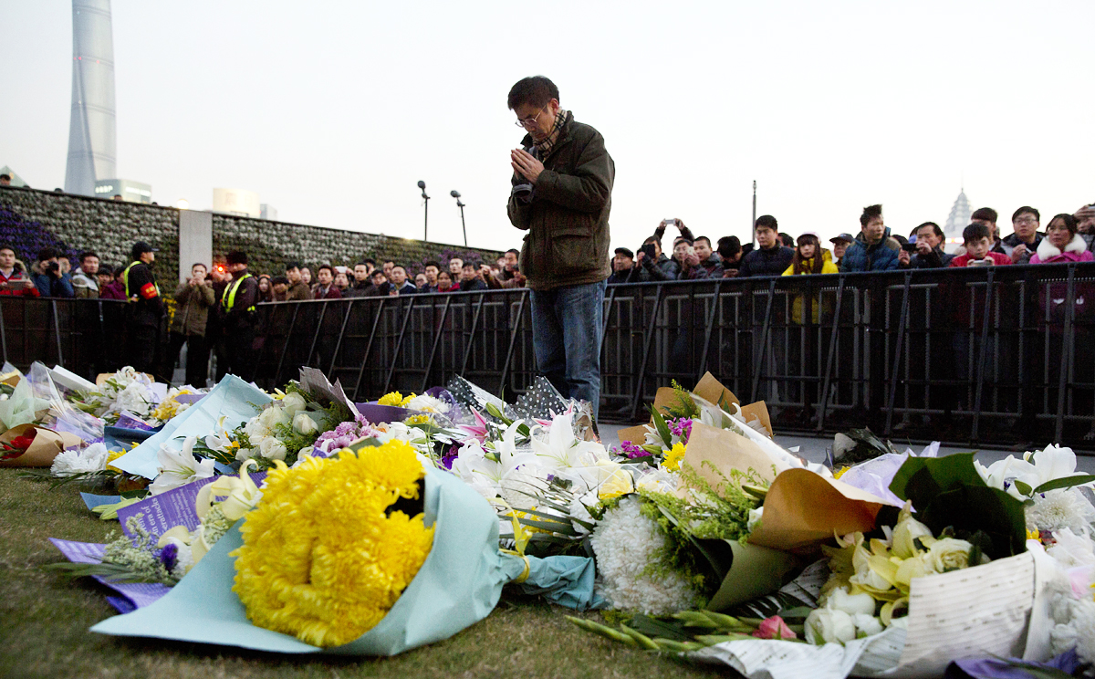 A man lays flowers at the scene of the disaster. Officials have defended the decision to punish only lower-level cadres for negligence. Photo: AP