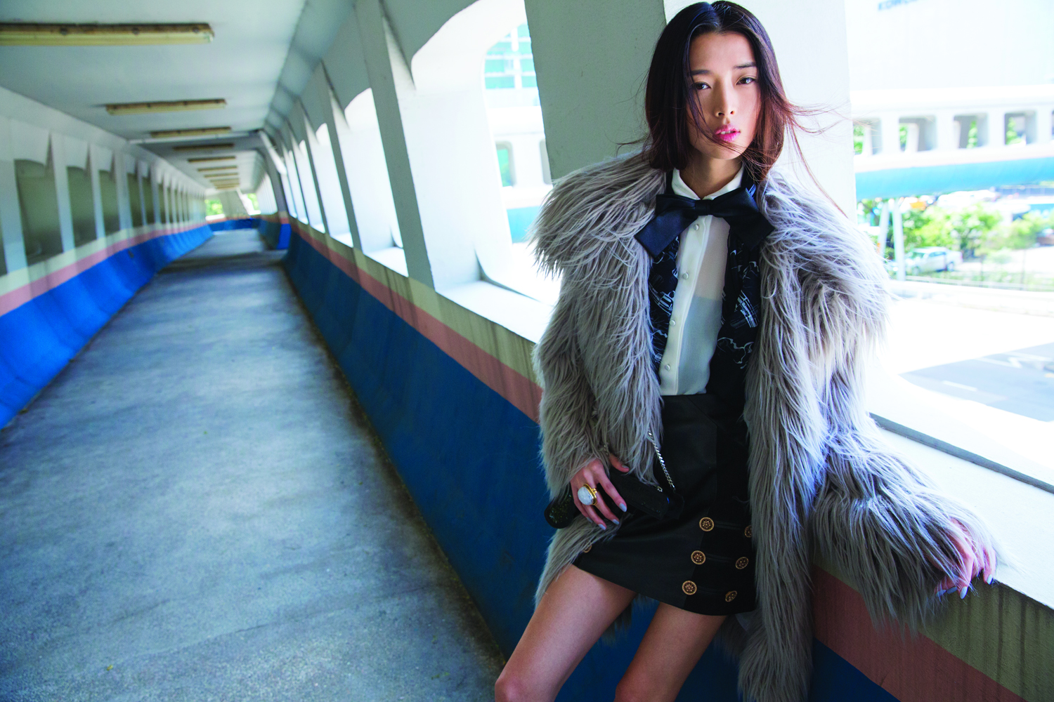 Faux fur coat (HK$30,000) by Lanvin. Shirt (HK$9,900), bow-tie (HK$3,450), scarf (HK$7,450), gun-shaped bag (HK$10,500) and ring (HK$4,750), all by Saint Laurent. Bandeau (worn under shirt; HK$1,200) by Ms Min. Leather skirt (HK$27,300) by Versace.