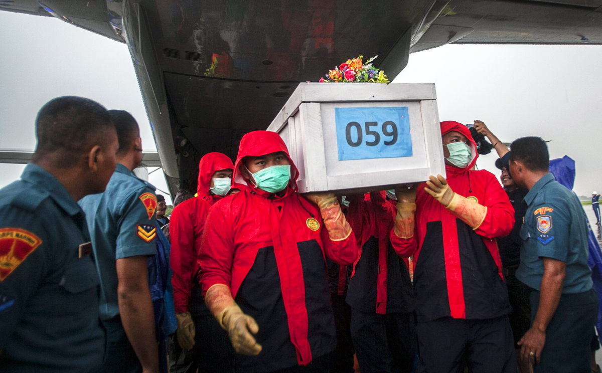 Indonesian rescue personnel unload a coffin bearing a body recovered from the underwater wreckage of the ill-fated AirAsia flight QZ8501. Photo: AFP